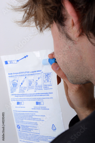 Photo: Profil masculin jeune soufflant dans un éthylotest Profil masculin jeune soufflant dans un éthylotest