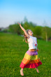 Happy little girl jumping in the summer park