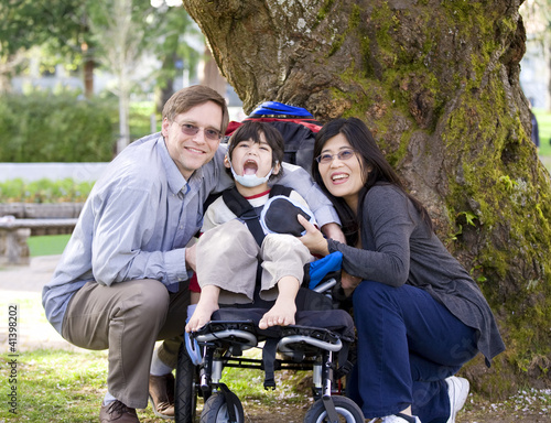 Photo: Disabled child surrounded by parents Disabled child surrounded by parents