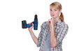 Woman secretly holding a drill