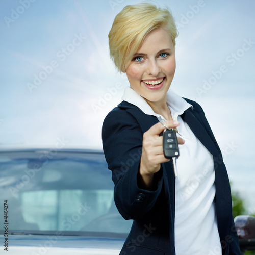Photo: Pretty blonde woman proudly presents the key of her car Pretty blonde woman proudly presents the key of her car