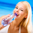 Foto: Woman with bottle of water on beach Woman with bottle of water on beach