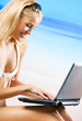 Foto: Woman with laptop on beach Woman with laptop on beach