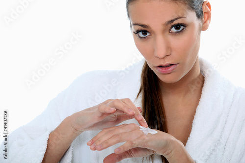 Photo: Attractive woman applying skin cream Attractive woman applying skin cream