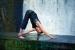 Fit  man streching on footbridge at the waterfall