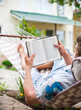 Man swinging inhammock reads a book Man swinging inhammock reads a book