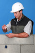 Mason checking quality of wall