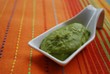 Green broad beans cream in white china dish on orange background Green broad beans cream in white china dish on orange background