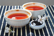 Two cups of tea, jar of tea leaves and cherry blossoms