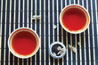 Two cups of tea, jar of tea leaves and cherry blossoms