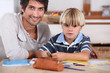 Little boy coloring with his father