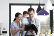 Photo: A couple and their baby son looking at a digital tablet A couple and their baby son looking at a digital tablet