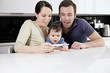 A couple and baby looking smiling about a pregnancy test result