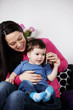 A mother and her baby son listening on a mobile phone