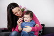 A mother and her baby son listening on a mobile phone