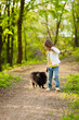 Cute little girl playing with dog in summer day