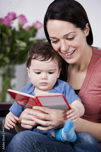 Photo: A mother and her baby son reading a book A mother and her baby son reading a book