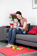 A mother and her baby son sitting on the sofa reading a book