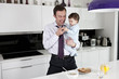 A father and his baby son looking at a telephone