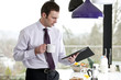 A businessman standing in a kitchen holding a digital tablet