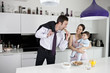 A couple and their baby son in the kitchen at breakfast time