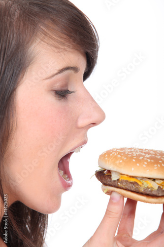 Photo: teenage girl eating an hamburger teenage girl eating an hamburger