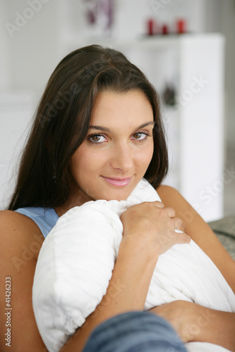 Foto: Woman hugging a pillow Woman hugging a pillow