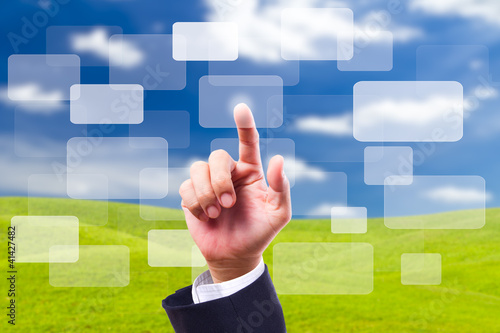 Photo: HAND pushing button on blue sky background HAND pushing button on blue sky background