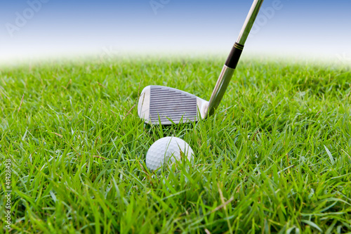 Photo: golf ball and iron on tall grass golf ball and iron on tall grass
