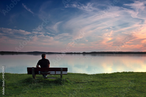 Foto: Mann auf Bank am See Mann auf Bank am See