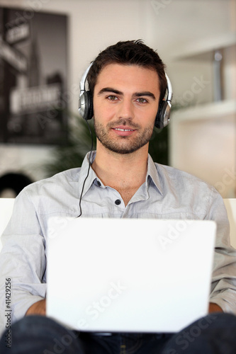 Foto: young music lover with earphones and laptop young music lover with earphones and laptop