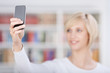 junge frau fotografiert sich mit handy