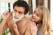 Woman looking at man shaving