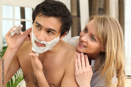 Foto: Woman looking at man shaving Woman looking at man shaving