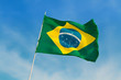 Brazil flag flutters against Brazilian blue skies