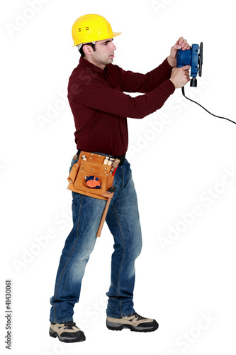 Foto: Man with an electric sander Man with an electric sander