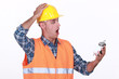 Shocked builder looking at alarm clock