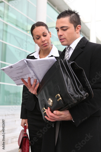 Foto: Businesspeople looking at a plan outdoors Businesspeople looking at a plan outdoors