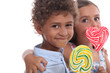 Two young children eating lollipops