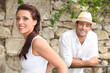 Couple standing by a stone wall Couple standing by a stone wall