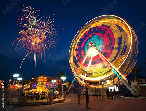 Foto: Amusement park at night - ferris wheel in motion and firework Amusement park at night - ferris wheel in motion and firework