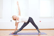 Woman doing stretching yoga exercise at sport gym Woman doing stretching yoga exercise at sport gym