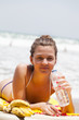 girl lies on  beach plank bed and holds  bottle with  water