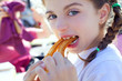 Blue eyes little girl eating churros smiling Blue eyes little girl eating churros smiling