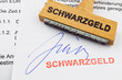 Holzstempel auf Dokument: Schwarzgeld Holzstempel auf Dokument: Schwarzgeld