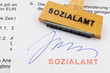 Holzstempel auf Dokument: Sozialamt