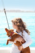 brunette kid girl with dog on the sea