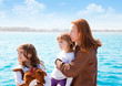 mother and daughter sister girls with dog on the sea
