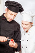 Senior chef teaches young chef to decorate fruit Senior chef teaches young chef to decorate fruit