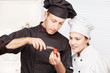 Senior chef teaches young chef to decorate fruit Senior chef teaches young chef to decorate fruit
